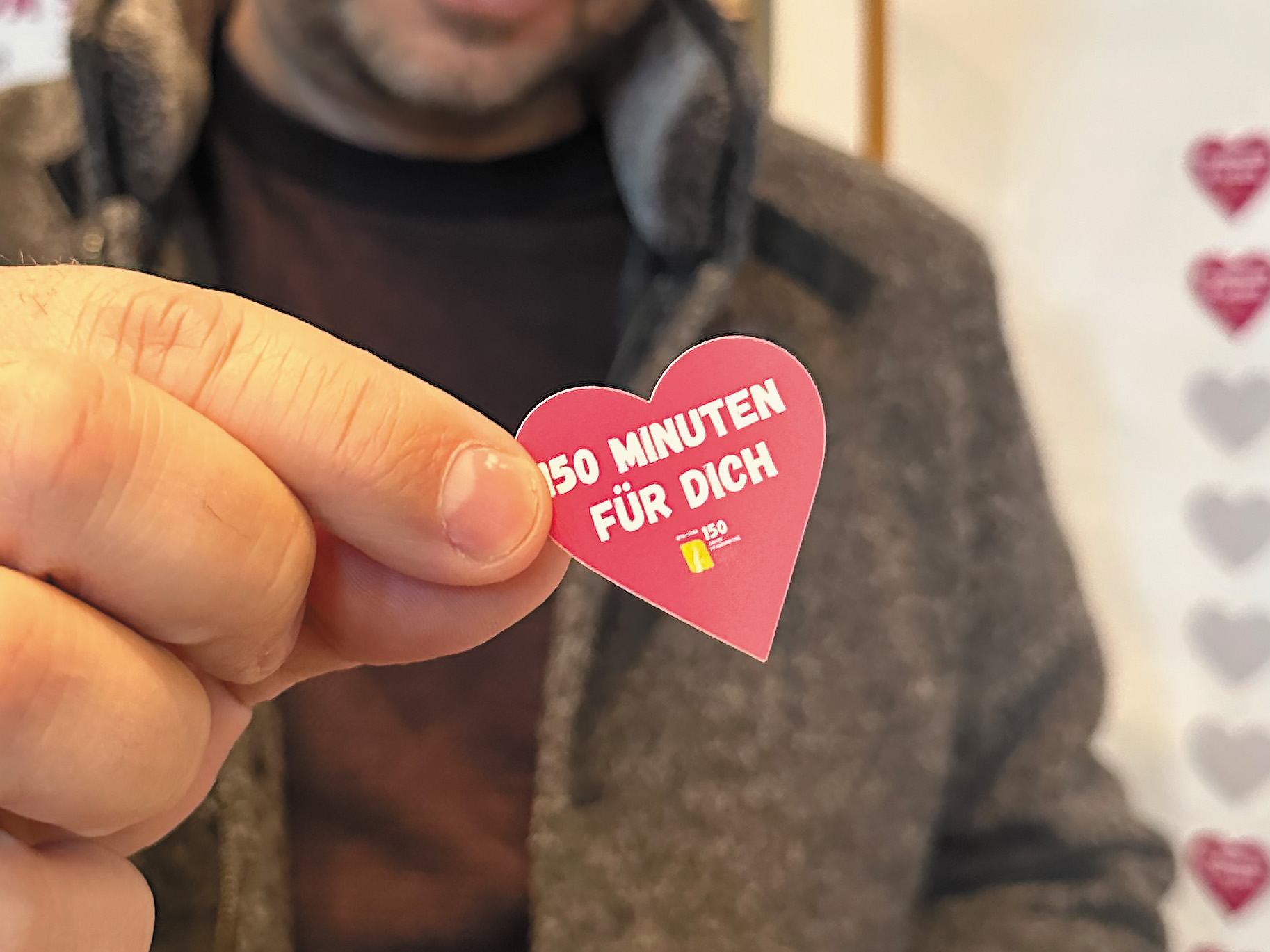 Jede und jeder, die/der mitmachen will, kann anonym ein kleines Herz auf eines der freien Felder an die Wand kleben.